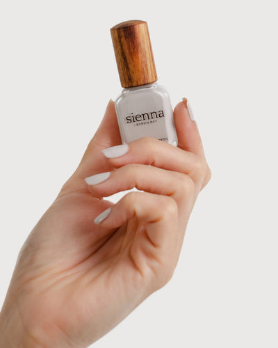 cool grey nail polish hand swatch on fair skin tone holding sienna bottle