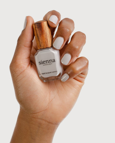 cool grey nail polish hand swatch on medium skin tone holding sienna bottle