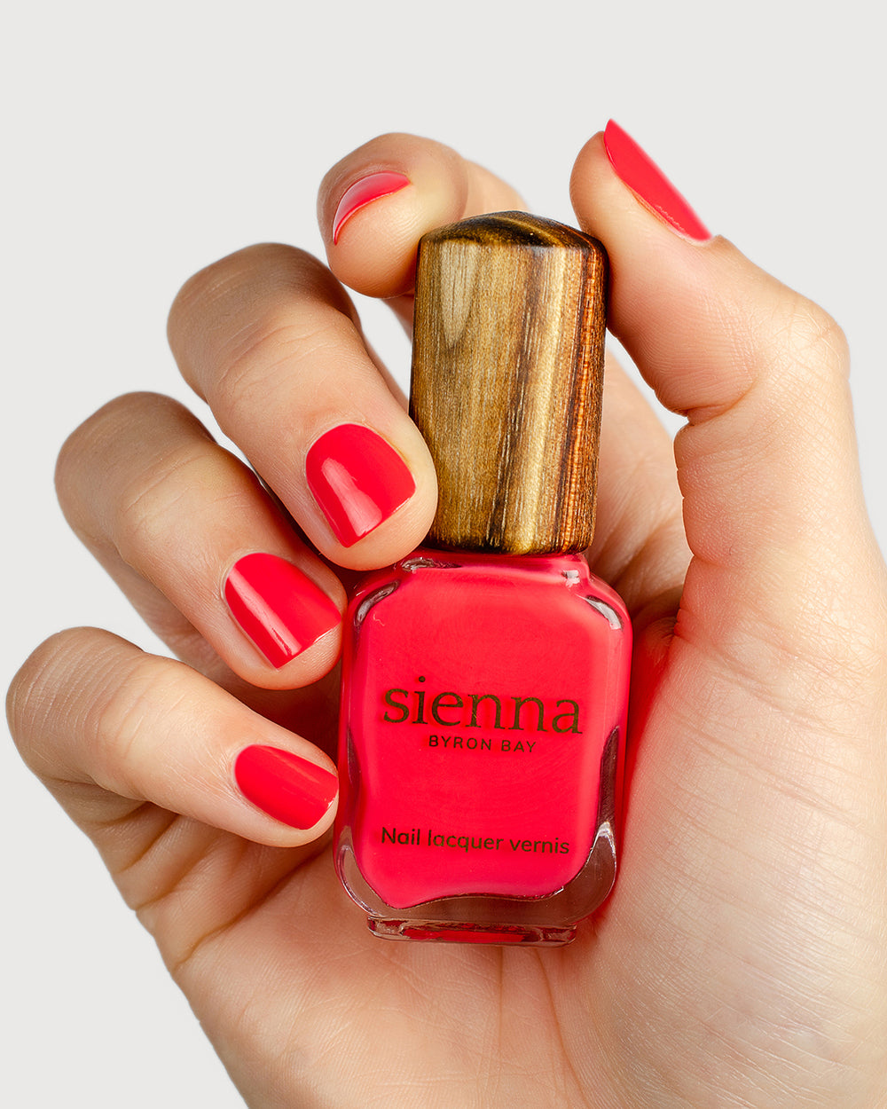barbie pink nail polish hand swatch on fair skin tone holding sienna bottle