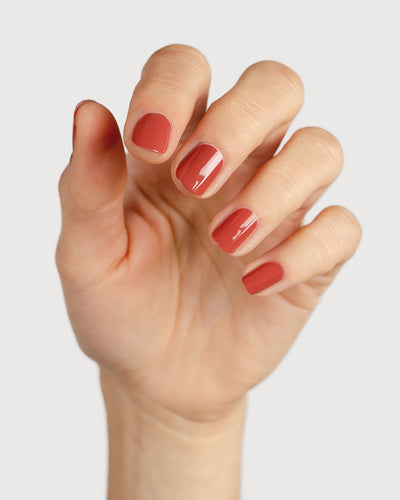 brick red nail polish hand swatch on fair skin tone