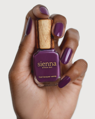 Reverence Violet Grape Crème nail polish by Sienna Byron Bay on medium skin tone hand.