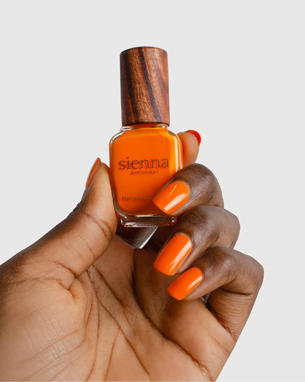 Bright papaya orange nail polish swatch on Dark Skin tone by Sienna Byron Bay