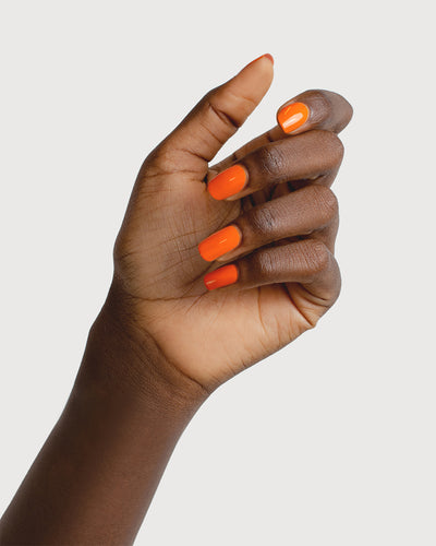 Bright papaya orange nail polish swatch on Dark Skin tone by Sienna Byron Bay