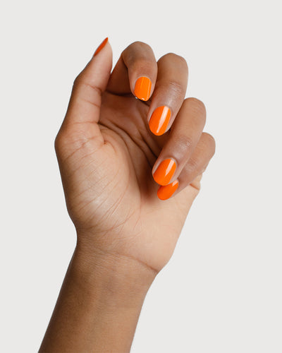 Bright papaya orange nail polish swatch on medium Skin tone by Sienna Byron Bay
